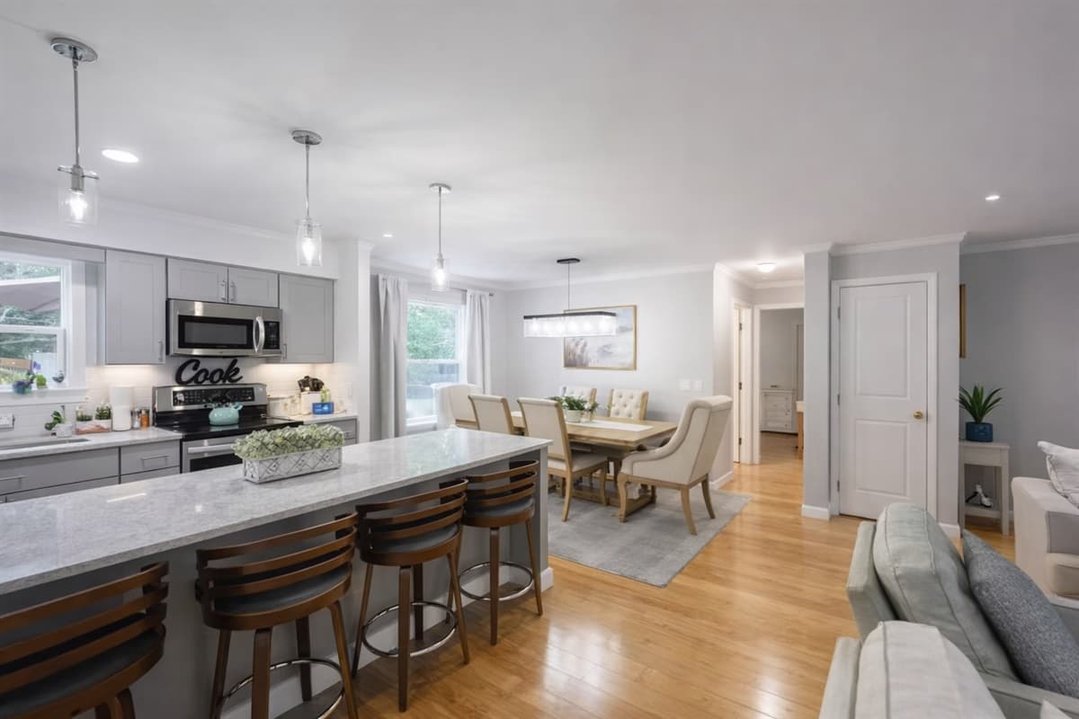Main kitchen with island seating, opening to the dining and living areas