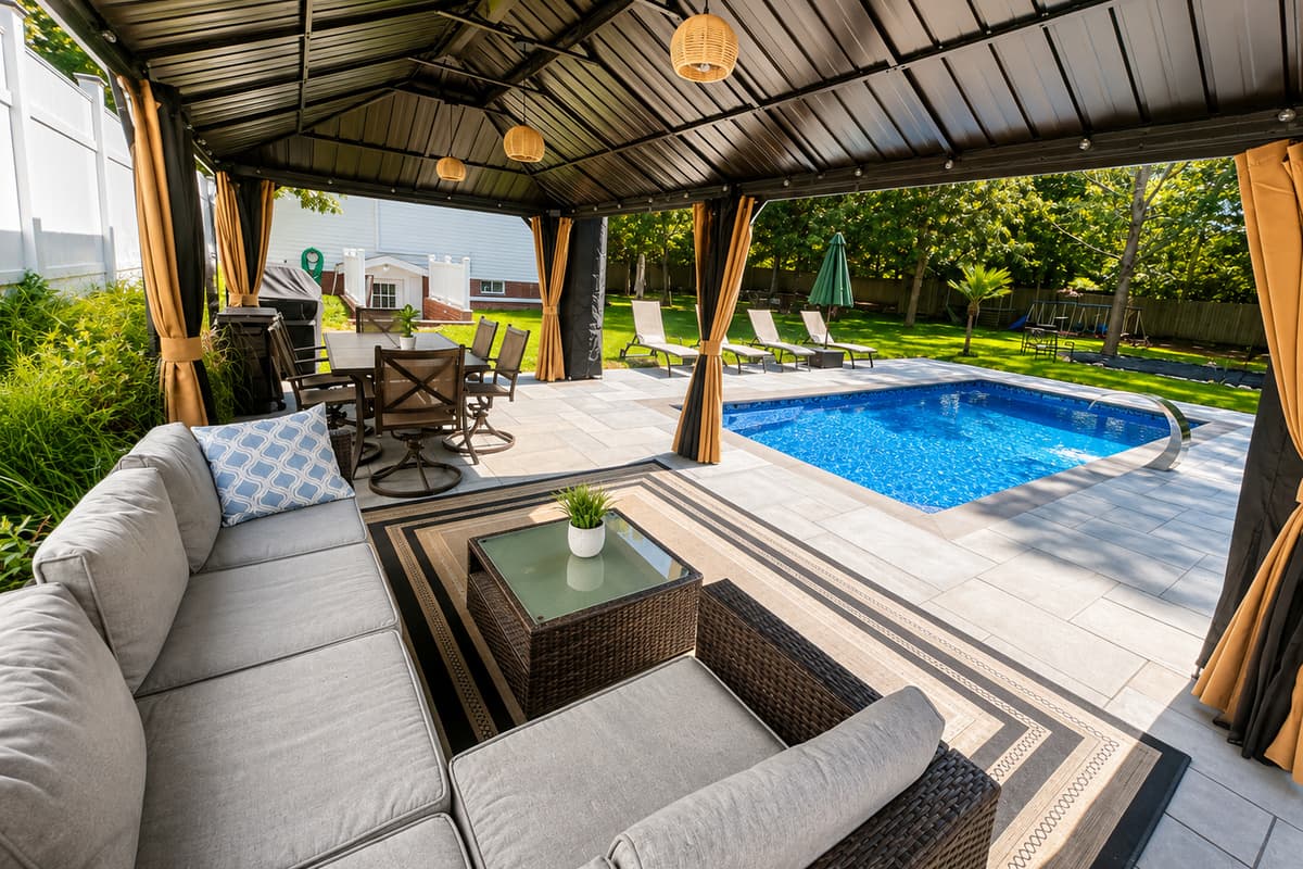 Covered outdoor lounge with plush seating overlooking the pool