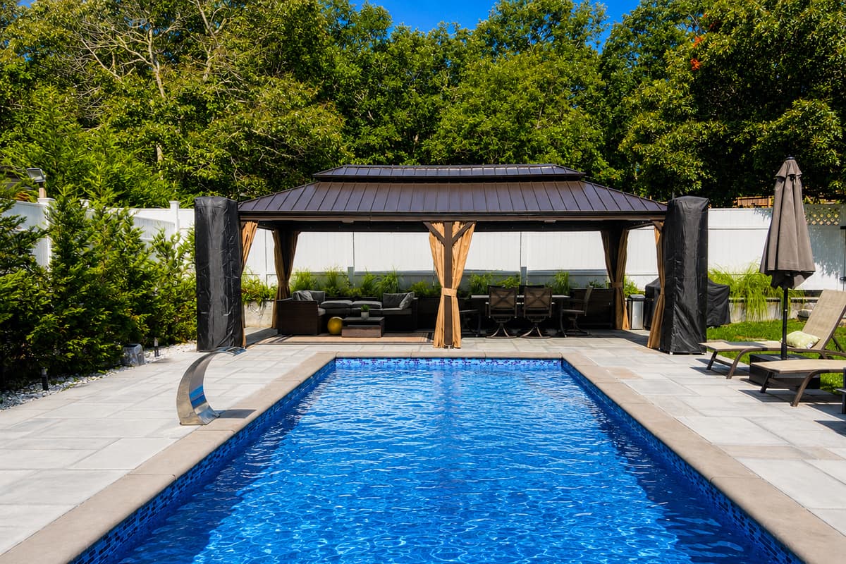 Sparkling heated pool framed by the shaded gazebo seating area